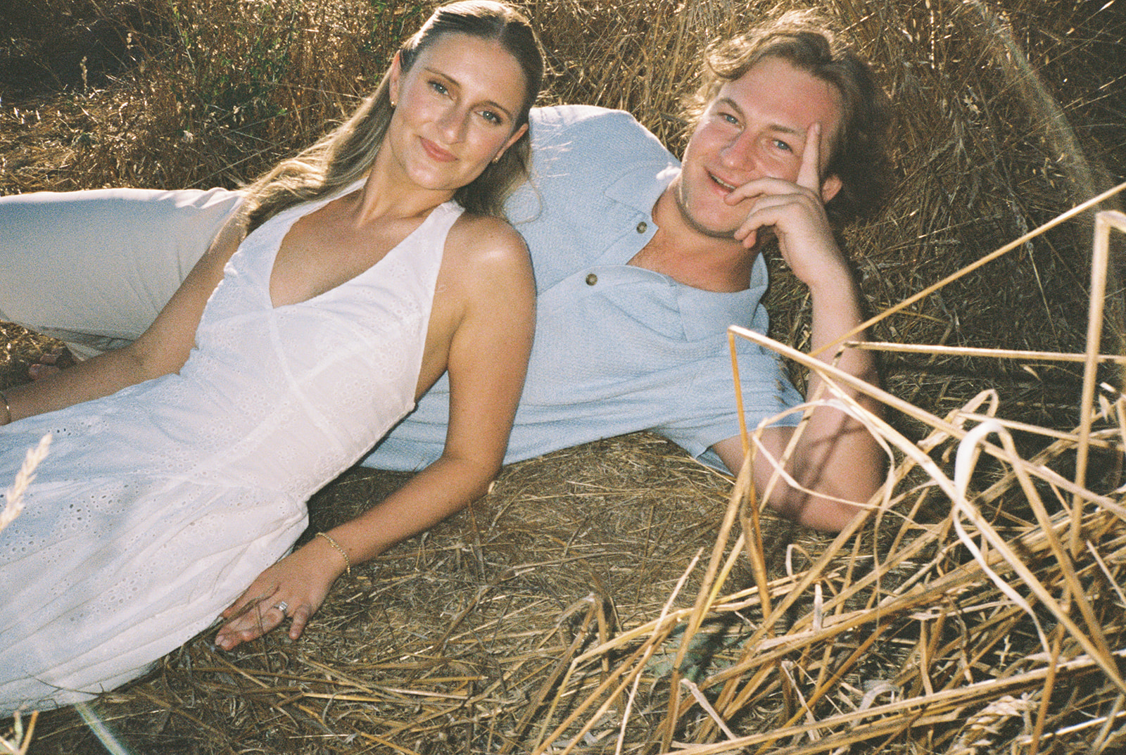 Chloe and Cal laughing together in a golden field